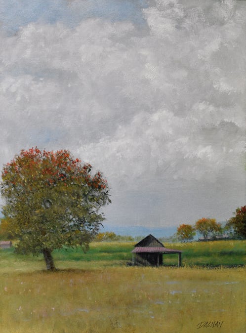 Landscape with farm building and early autumn trees and cululus clouds
